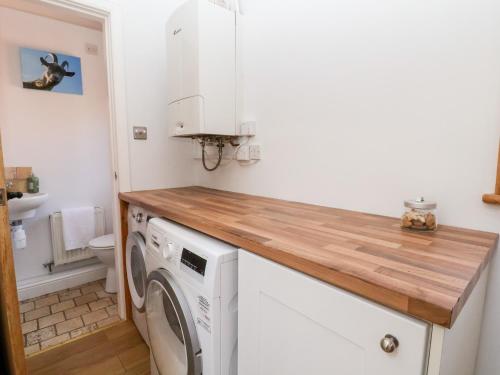 a kitchen with a washer and dryer in a room at Jasmine Cottage in Chester
