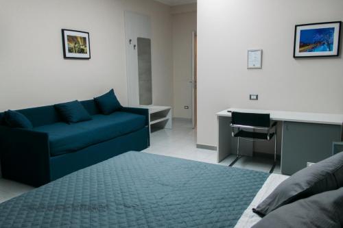 a living room with a blue couch and a desk at Gianturco Bed and Breakfast in Avigliano