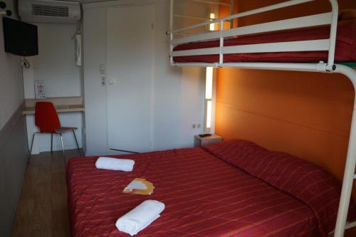 a bedroom with a bunk bed with two towels on it at Premiere Classe Laon in Laon
