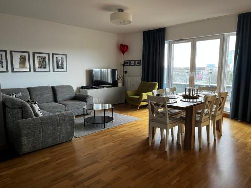 - un salon avec un canapé et une table avec des chaises dans l'établissement APT Nadmorskie - Solna, à Kołobrzeg