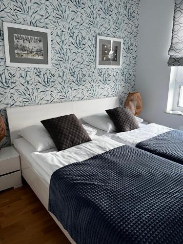 コウォブジェクにあるAPT Nadmorskie - Solnaのベッドルーム1室(青と白のパターンの壁のベッド1台付)