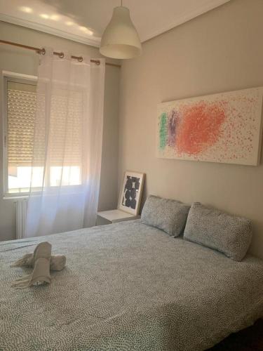 1 dormitorio con 1 cama con sombrero en Apartamento a 200 metros paseo zorrilla en Valladolid