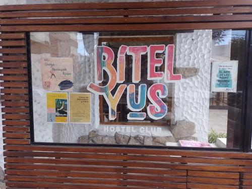 Una ventana con un cartel que dice infierno contra un club de hotel en Bitelyus Hostel Club en Mar del Plata