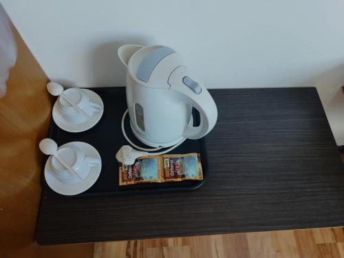 una cafetera sentada en una mesa con dos tazas en Marine Bay Hotel, en Sandakan