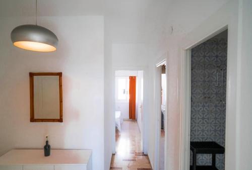 a white room with a hallway with a mirror at Luminoso ático con vistas al mar in Almería