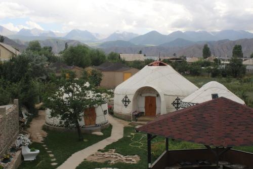 a group of tents with mountains in the background at Guest House Emily in Bokonbayevo