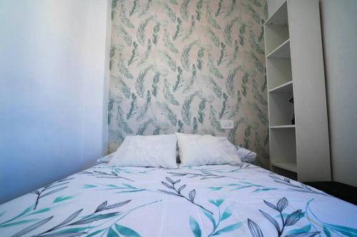 a bedroom with a bed with a floral wallpaper at Luminoso ático con vistas al mar in Almería