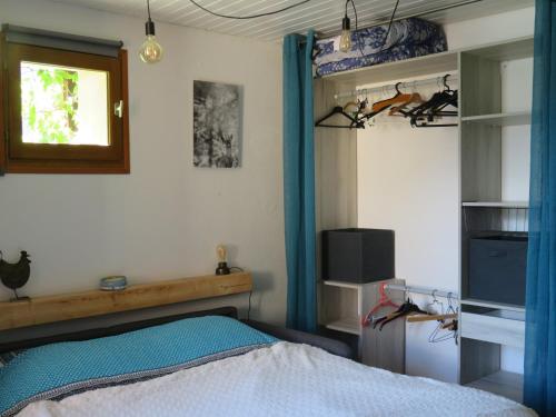 a bedroom with a bed with a blue curtain at Studio en rez de chaussée, avec jardin partagé. in Vars