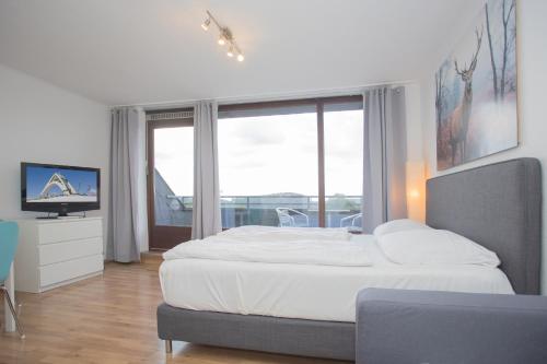 a bedroom with a large bed and a large window at Apartments Am Waltenberg 57-59 in Winterberg