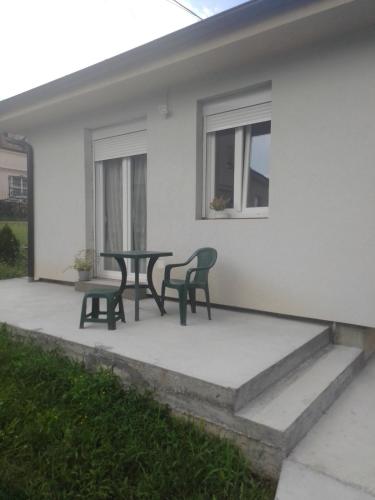 a patio with two chairs and a table in front of a house at Apartman SLADJANA Vrnjacka Banja in Vrnjačka Banja