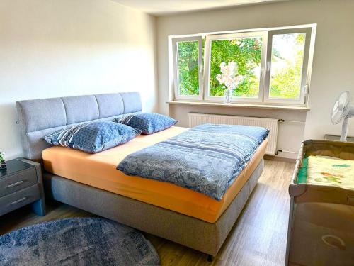 una camera da letto con un letto con cuscini blu e una finestra di Traumhaftes Zuhause! a Forstinning