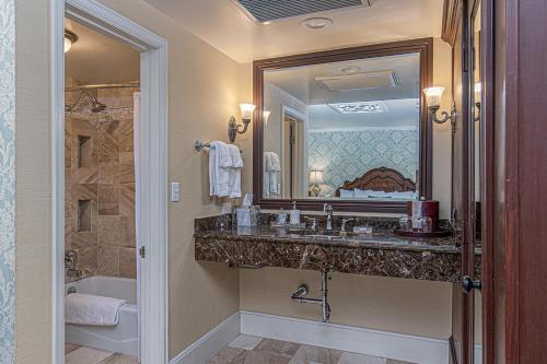 a bathroom with a sink and a mirror and a tub at General Palmer Hotel in Durango