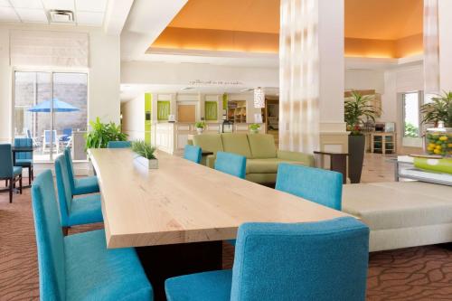 comedor con mesa y sillas azules en Hilton Garden Inn Atlanta North/Johns Creek, en Johns Creek