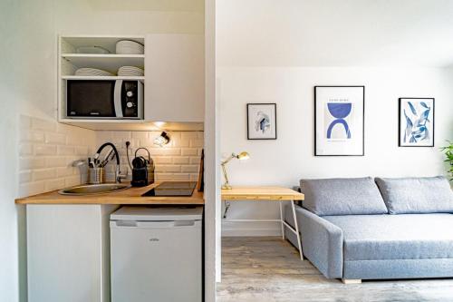 a kitchen and living room with a couch and a table at Le petit Dauphiné-studio rénové-Sans soucis in Lyon