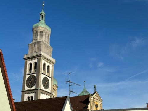 una torre de reloj en la parte superior de un edificio en TRULY - Direkt am Rathausplatz, Dachterrasse mit Blick auf Perlachturm, Garage, Fahrstuhl en Augsburg