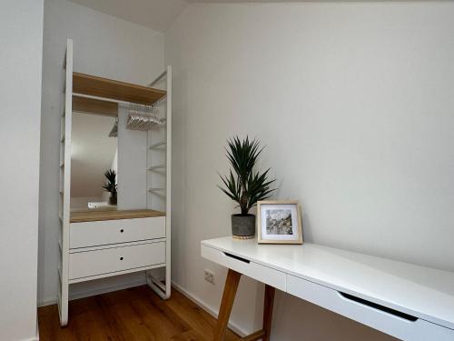 una camera da letto con scrivania bianca e armadio di TRULY - Direkt am Rathausplatz, Dachterrasse mit Blick auf Perlachturm, Garage, Fahrstuhl a Augusta (Augsburg)