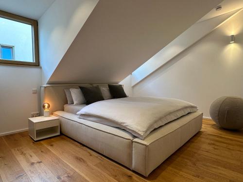 Tempat tidur dalam kamar di TRULY - Direkt am Rathausplatz, Dachterrasse mit Blick auf Perlachturm, Garage, Fahrstuhl