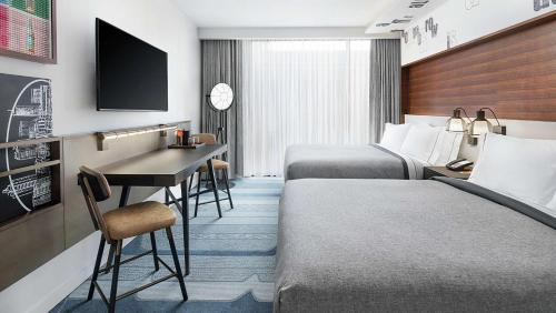 a hotel room with two beds and a desk at Canopy By Hilton Atlanta Midtown in Atlanta