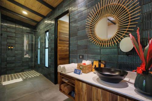 a bathroom with a sink and a mirror at Exôtico Beach Hotel in Puerto Viejo
