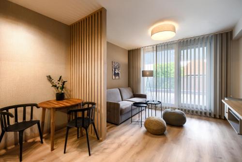 a living room with a couch and a table and chairs at AboutArtApartments - Otyńska 4 in Wrocław