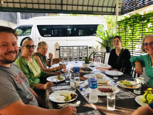 een groep mensen die rond een tafel eten bij Pinidiya Resort in Anuradhapura