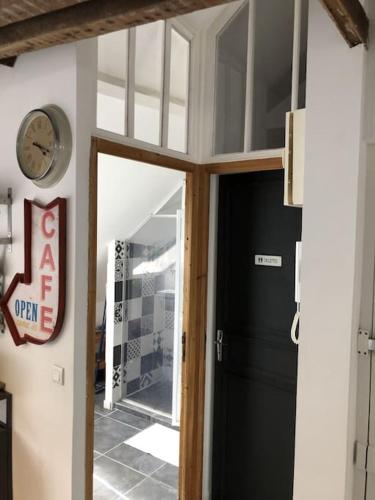 une porte dans une pièce avec une horloge sur le mur dans l'établissement T4 hyper centre d' Angers, à Angers