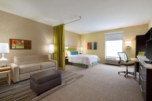 a hotel room with a bed and a couch at Home2 Suites by Hilton Cincinnati Liberty Township in Wetherington