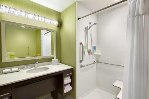 a bathroom with a sink and a shower with a mirror at Home2 Suites by Hilton Cincinnati Liberty Township in Wetherington