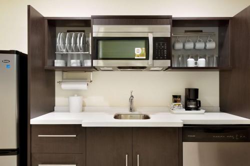 a kitchen with a sink and a microwave at Home2 Suites by Hilton Cincinnati Liberty Township in Wetherington