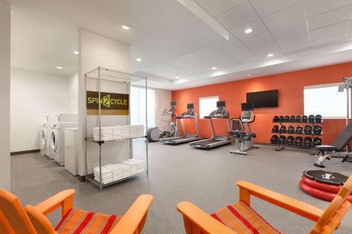 a fitness room with a gym with orange walls at Home2 Suites By Hilton El Paso Airport in El Paso