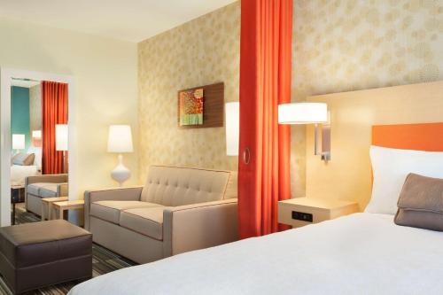 a hotel room with a bed and a couch at Home2 Suites By Hilton El Paso Airport in El Paso