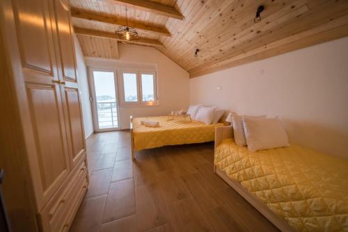 een grote kamer met 2 bedden en een raam bij Apartmani Šarović Tara 3 in Rača