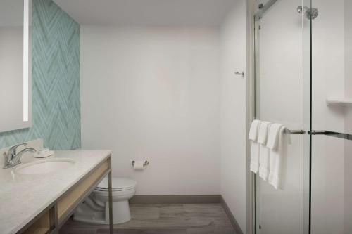 a bathroom with a toilet and a sink and a shower at Hilton Garden Inn Orlando Downtown in Orlando