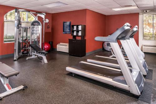 a gym with cardio equipment in a room with red walls at Hampton Inn Fort Lauderdale Plantation in Plantation