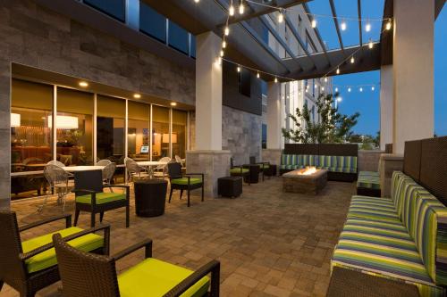 a patio with chairs and tables and a fireplace at Home2 Suites by Hilton Phoenix Chandler in Chandler