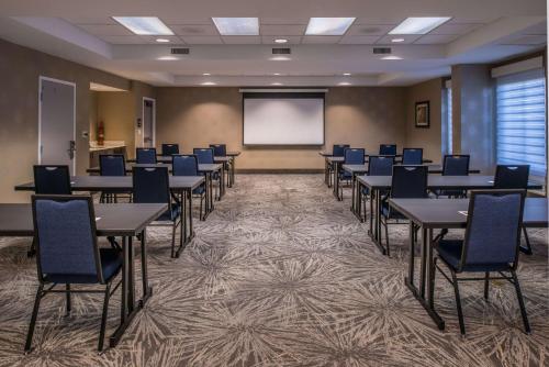 a conference room with tables and chairs and a screen at Hampton Inn Fort Lauderdale Plantation in Plantation