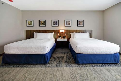 two beds in a hotel room with two at Hilton Garden Inn Jackson in Jackson