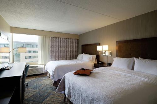 a hotel room with two beds and a window at Hampton Inn Green Bay Downtown in Green Bay