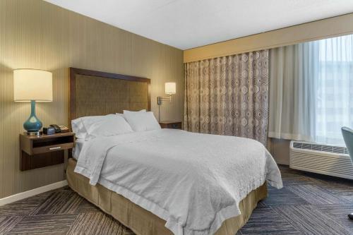 a hotel room with a large bed and a window at Hampton Inn Green Bay Downtown in Green Bay