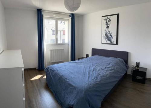 une chambre avec un lit bleu et une fenêtre dans l'établissement La villa des quais de Seine et jacuzzi prox Paris, à Sartrouville