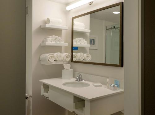 a bathroom with a sink and a mirror and towels at Hampton Inn Green Bay Downtown in Green Bay