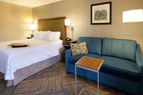 a hotel room with a bed and a couch at Hampton Inn Green Bay Downtown in Green Bay