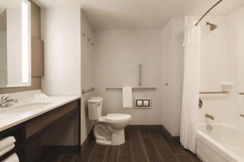a bathroom with a toilet and a sink and a tub at Hilton Garden Inn Phoenix-Tempe University Research Park, Az in Tempe