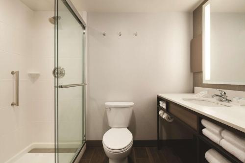 a bathroom with a toilet and a glass shower at Hilton Garden Inn Phoenix-Tempe University Research Park, Az in Tempe