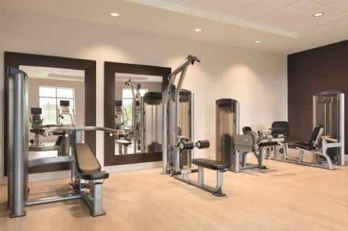 a gym with several tread machines and mirrors at Home2 Suites By Hilton Phoenix-Tempe University Research Park in Tempe