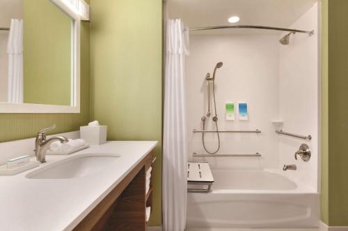 a bathroom with a tub and a sink and a shower at Home2 Suites By Hilton Phoenix-Tempe University Research Park in Tempe