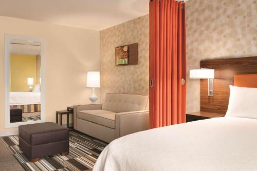 坦培Home2 Suites By Hilton Phoenix-Tempe University Research Park的配有床和沙发的酒店房间