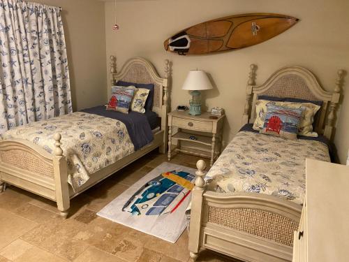 a bedroom with two beds and a surfboard on the wall at Venice Dream Vacations, Centrally Located, Just Waiting For You in Venice