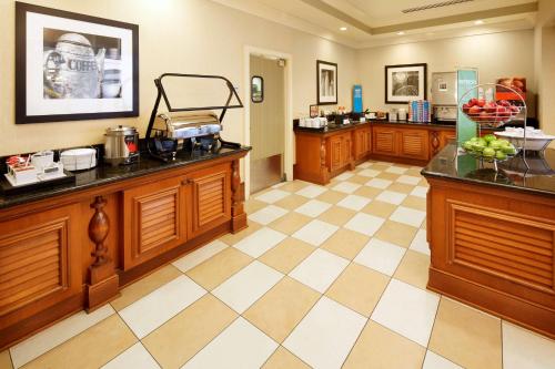 a kitchen with wooden cabinets and a checkered floor at Hampton Inn & Suites Savannah/Midtown in Savannah