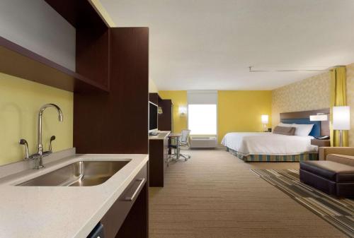 Großes Hotelzimmer mit einem Bett und einer Küche in der Unterkunft Home2 Suites by Hilton Pittsburgh - McCandless, PA in McCandless Township